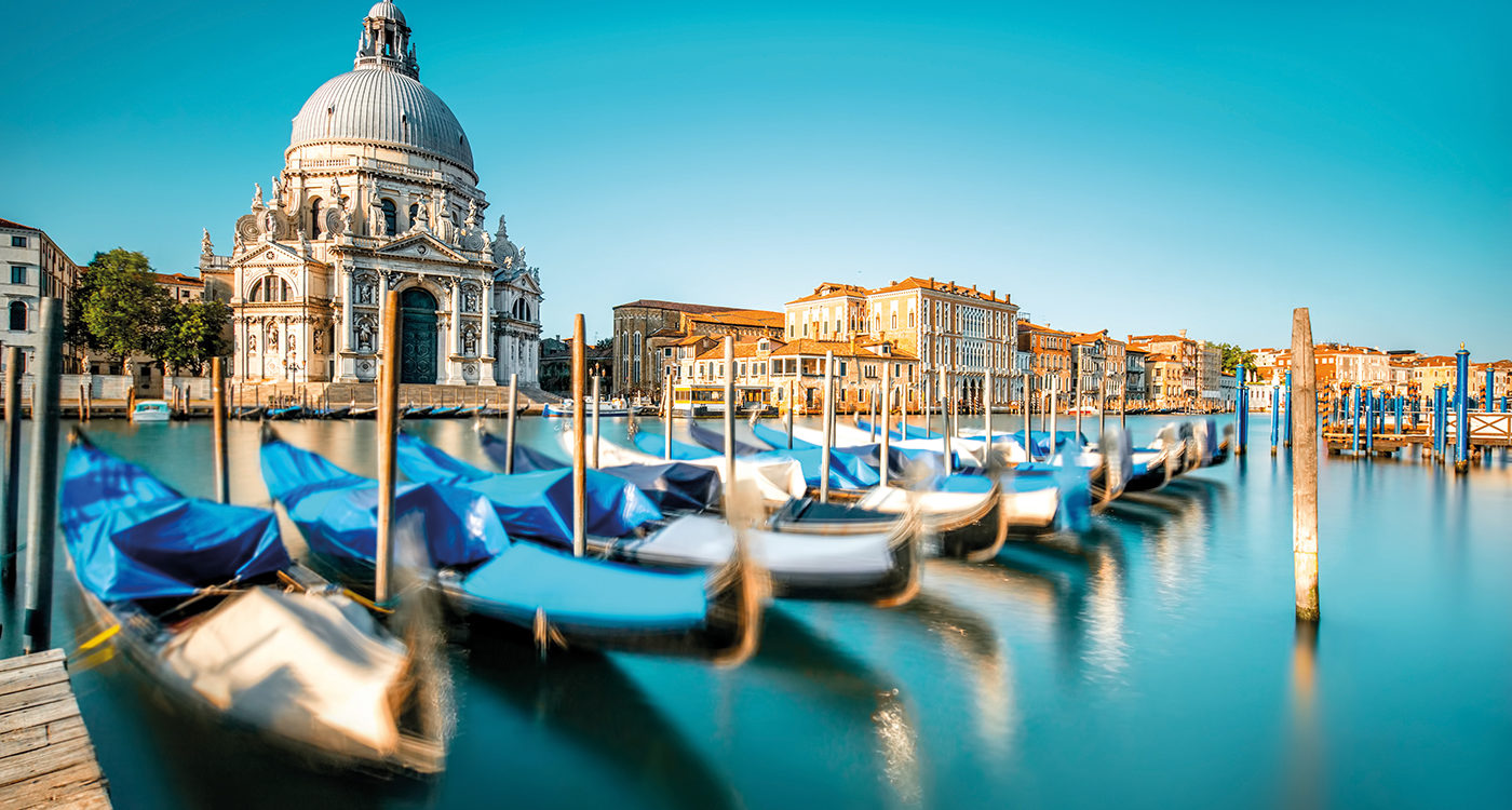 Venice cityscape view on Santa Maria della Salute basilica with gondolas on the Grand canal in Venice. Long exposure image technic with motion brured boats